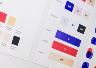 Zbliżenie na ekran komputera, na którym znajduje się otwarty program graficzny z pokładanymi próbkami kolorów, testami kontrastu tekstu na kolorze i nałożonymi na siebie kolorami, aby sprawdzić ich spójność.